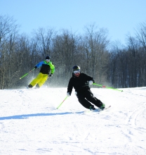 Skiers speeding downhill at HoliMont